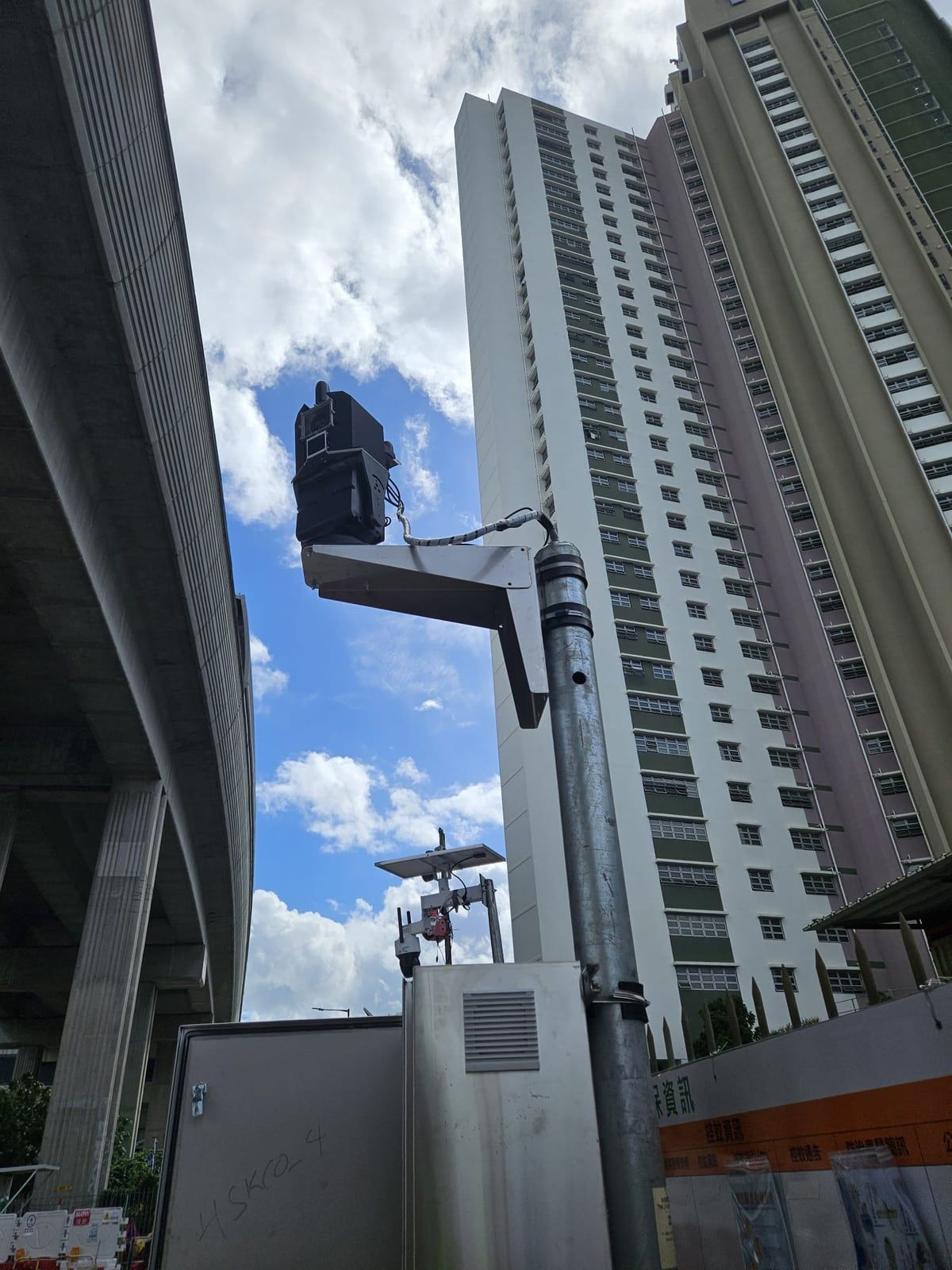 جهاز LiDAR من Kodifly على عمود بجانب جسر علوي ومجمع سكني عام